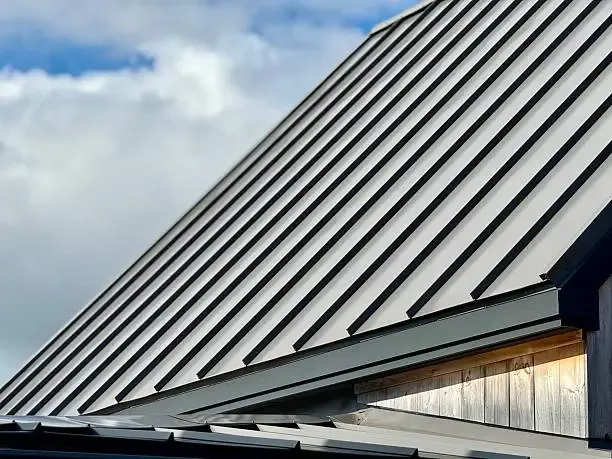 Slope of standing seam metal roofing above a wood soffit