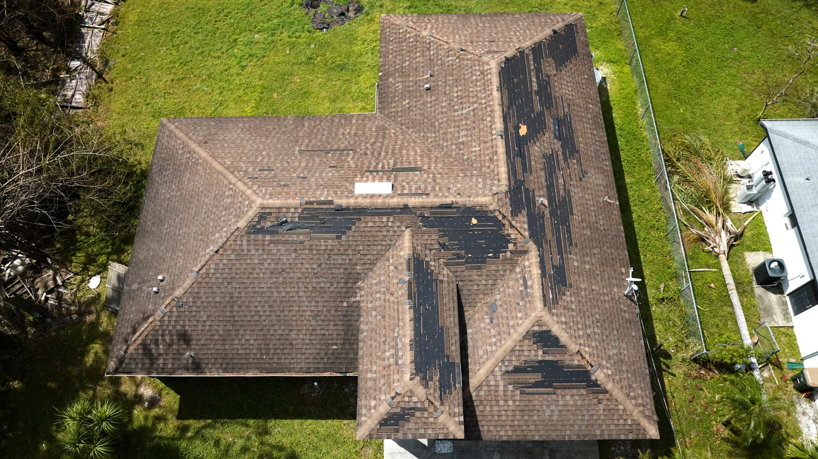 Aerial view of a roof with many shingles torn away